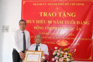 胡志明市市委副书记阮福禄向范玉隐同志颁授80年党龄纪念章。图：泰芳